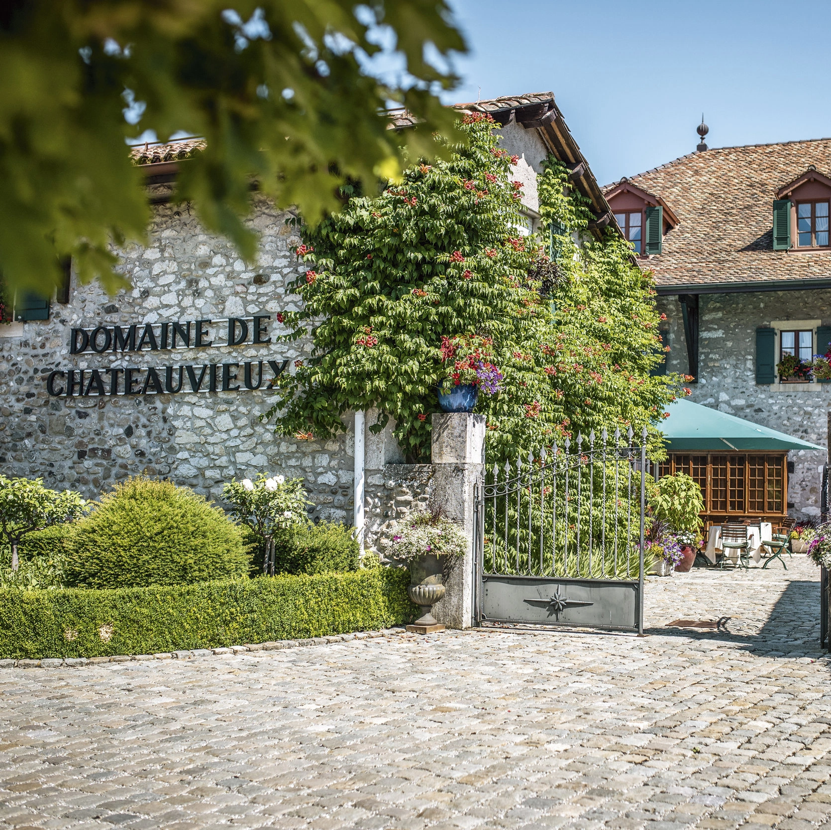 the entrance gate and front garden of the restaurant Domaine de Châteauvieux 